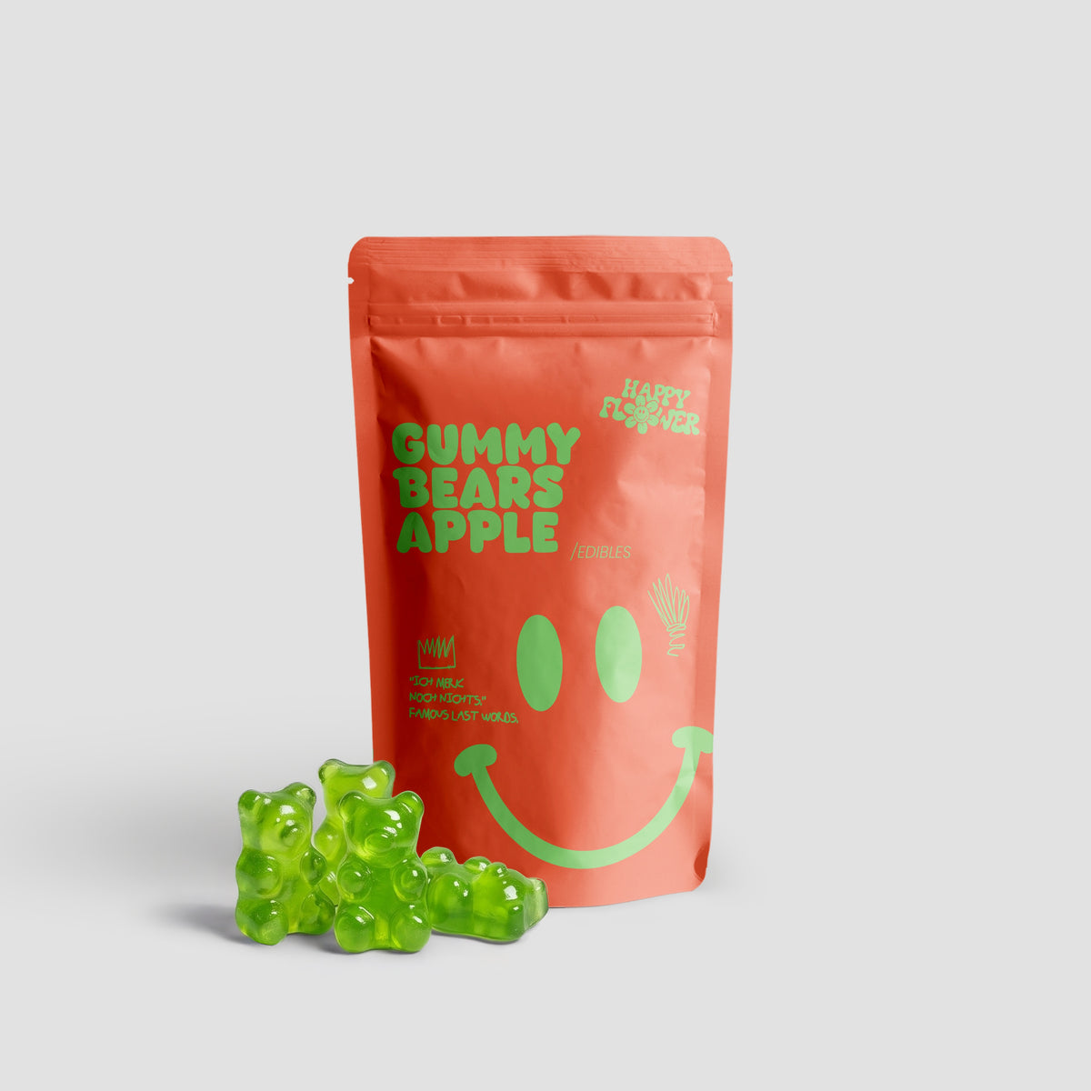 Happy Flower Gummy Bears Apple Edibles in korallfarbener Standbeutel-Verpackung mit mehreren grünen Gummibärchen im Vordergrund auf hellem Hintergrund.
