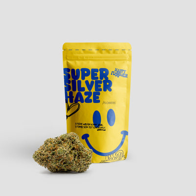 Happy Flower Super Silver Haze Flowers in gelber Standbeutel-Verpackung mit einer großen Cannabisblüte im Vordergrund auf hellem Hintergrund.