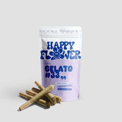 Happy Flower Gelato #33 Joints in weiß-lilafarbener Standbeutel-Verpackung mit mehreren vorgedrehten Joints im Vordergrund auf hellem Hintergrund.
