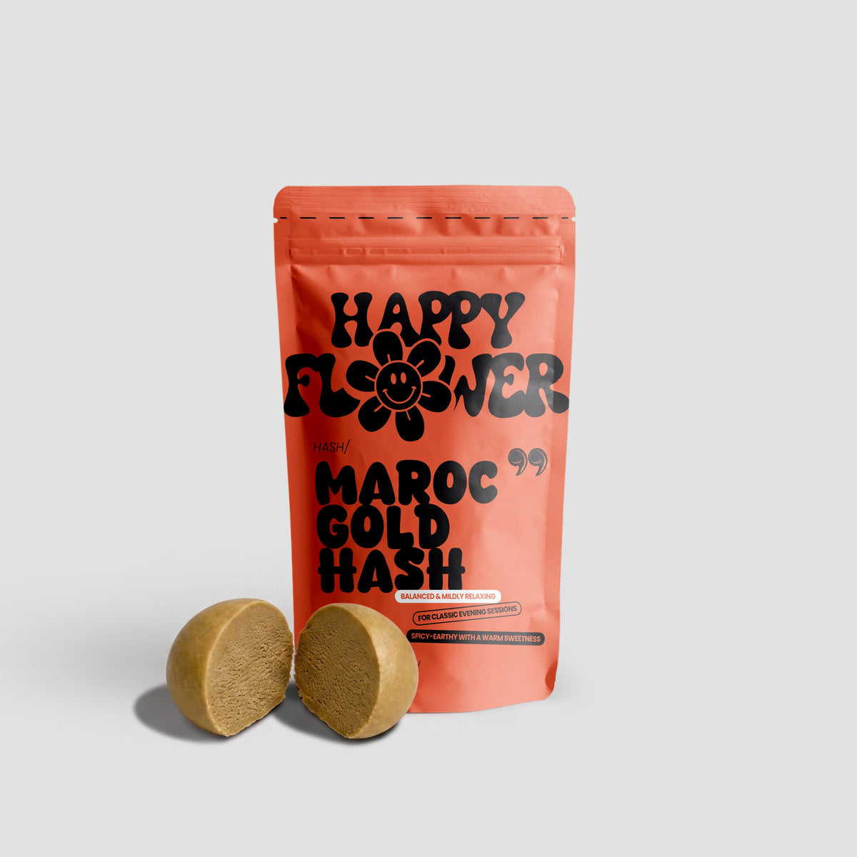 Happy Flower Maroc Gold Hash in korallfarbener Standbeutel-Verpackung mit zwei angeschnittenen goldbraunen Hasch-Stücken auf hellem Hintergrund.