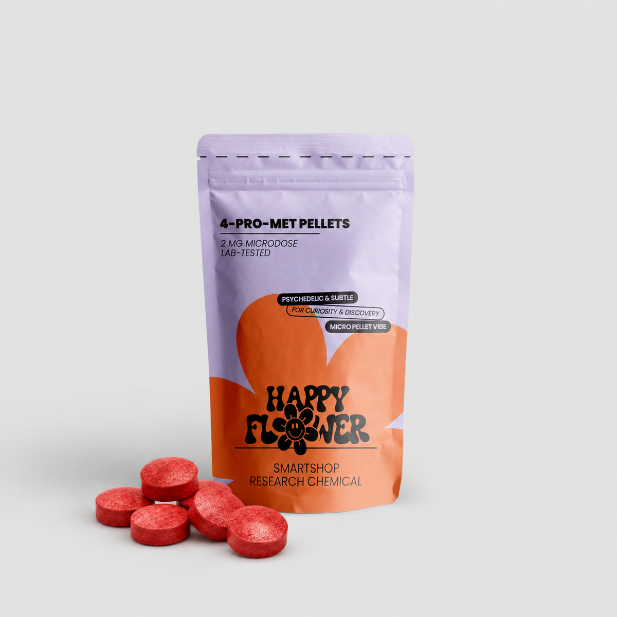 Happy Flower 4-PRO-MET Pellets 2 mg in lilafarben-korallfarbener Standbeutel-Verpackung mit mehreren roten Pellets im Vordergrund auf hellem Hintergrund.