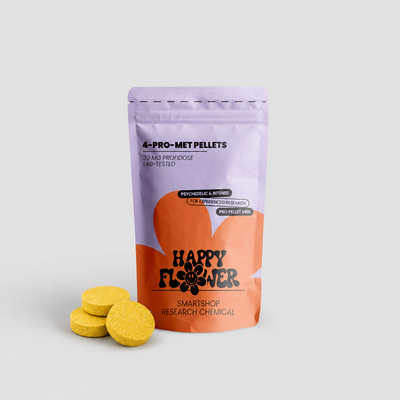 Happy Flower 4-PRO-MET Pellets 30 mg in lilafarben-korallfarbener Standbeutel-Verpackung mit drei gelben Pellets im Vordergrund auf hellem Hintergrund.