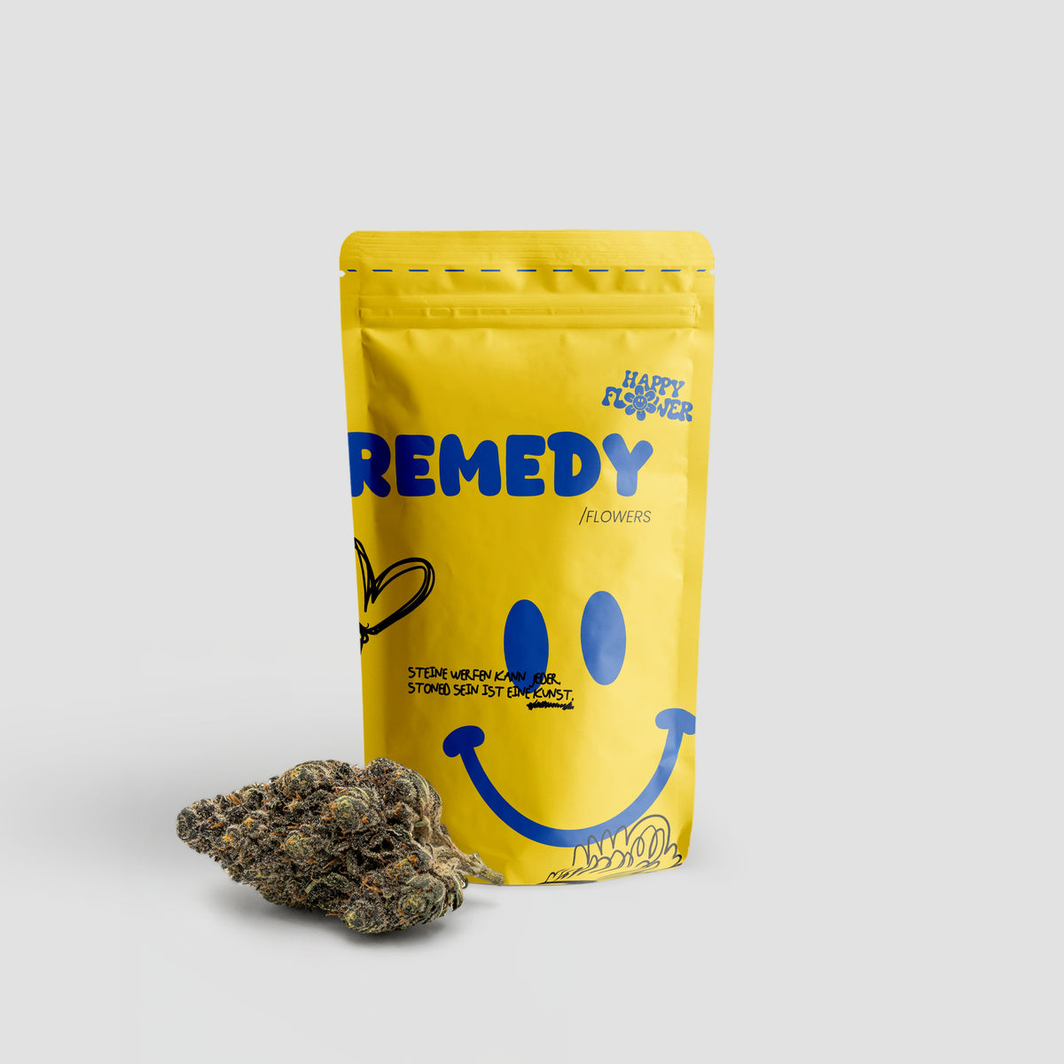 Happy Flower Remedy Flowers in gelber Standbeutel-Verpackung mit einer dunklen Cannabisblüte im Vordergrund auf hellem Hintergrund.