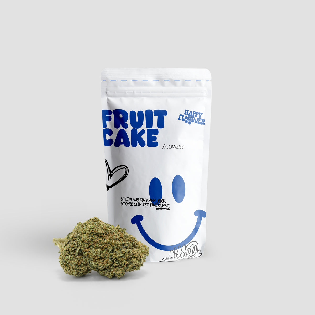 Happy Flower Fruit Cake CBD Flowers in weißer Standbeutel-Verpackung mit zwei Cannabisblüten im Vordergrund auf hellem Hintergrund.