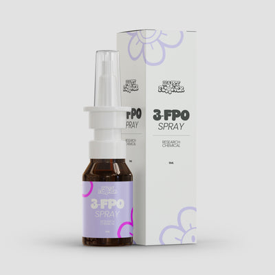 Braune 5-ml-Sprühflasche mit weißem Nasenaufsatz und transparenter Schutzkappe vor der passenden weißen Produktverpackung. Flasche und Karton tragen das Happy-Flower-Logo sowie die Aufschrift „3-FPO Spray – Research Chemical“ und lilafarbene Blütenelemente.