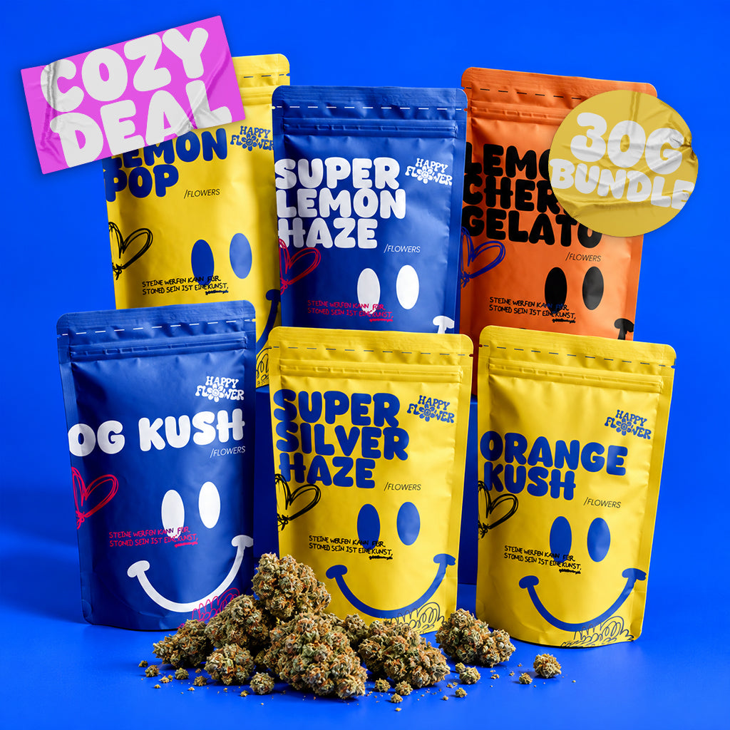 Sechs bunte Happy Flower Blüten-Baggys in Blau, Gelb und Orange, ästhetisch arrangiert vor einem kräftig blauen Hintergrund. Im Vordergrund liegt ein kleiner Haufen Blüten mit natürlichen Schatten.