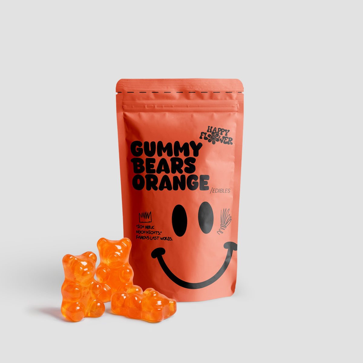 Happy Flower Gummy Bears Orange Edibles in korallfarbener Standbeutel-Verpackung mit mehreren orangefarbenen Gummibärchen im Vordergrund auf hellem Hintergrund.