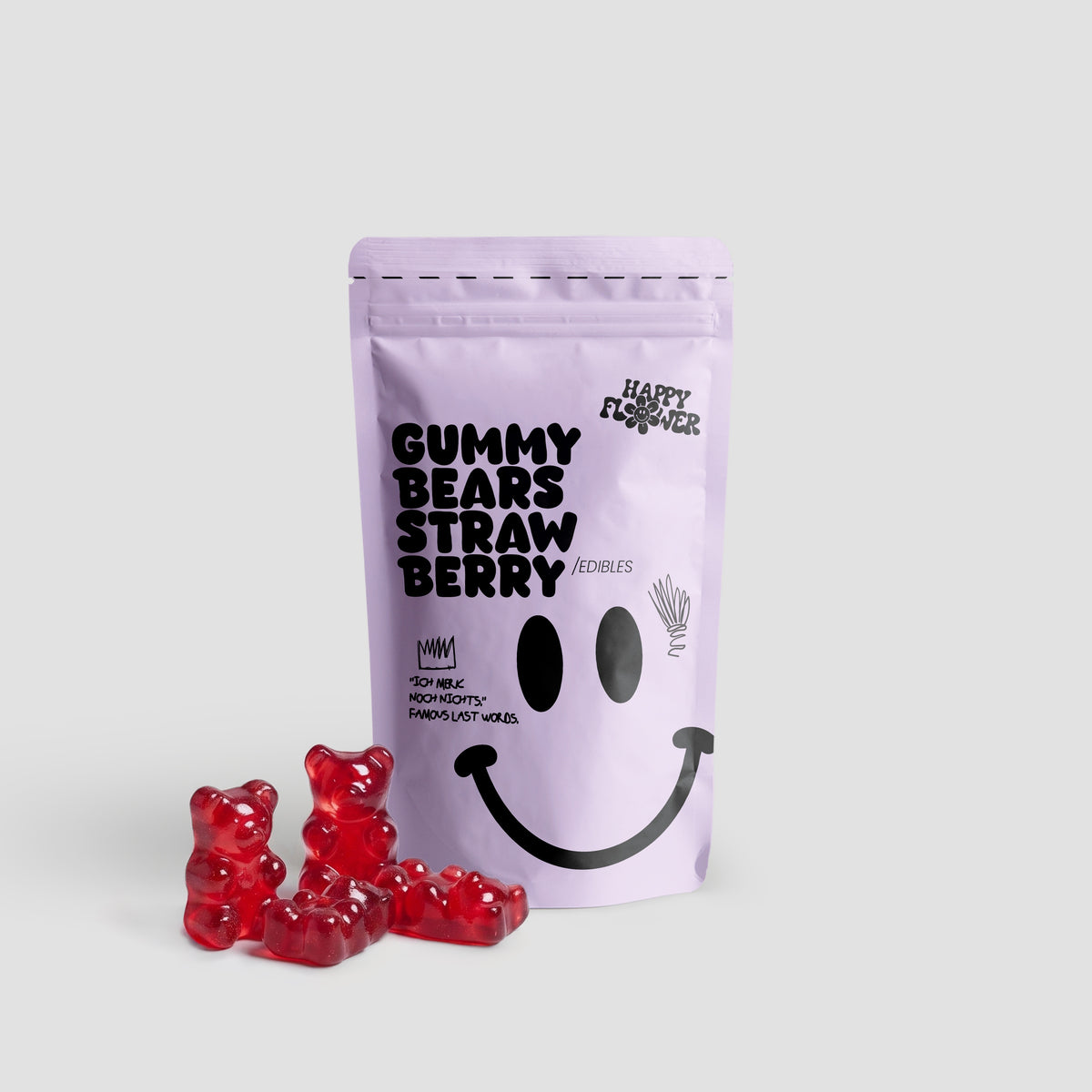 Happy Flower Gummy Bears Strawberry Edibles in lilafarbener Standbeutel-Verpackung mit mehreren roten Gummibärchen im Vordergrund auf hellem Hintergrund.
