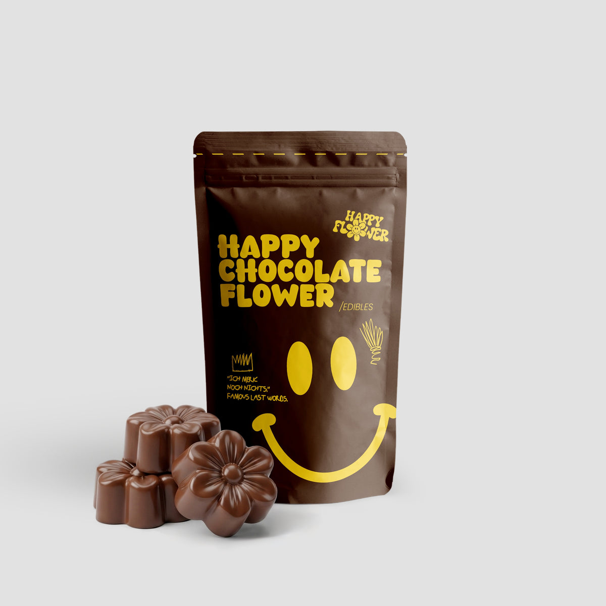Happy Flower Happy Chocolate Flower Edibles in brauner Standbeutel-Verpackung mit mehreren blütenförmigen Schokoladenstücken im Vordergrund auf hellem Hintergrund.